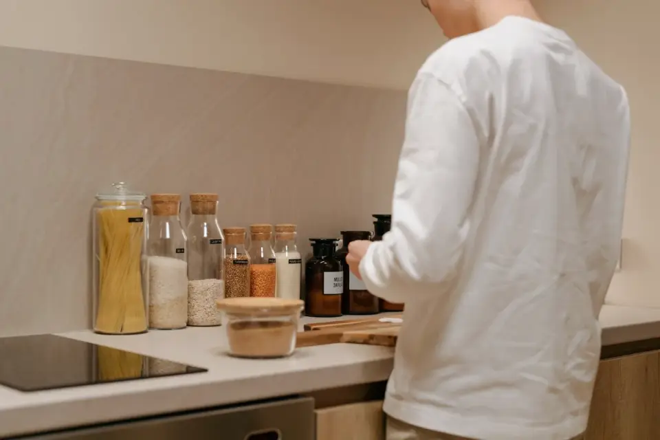 A dog standing near a kitchen counter looking up at food
