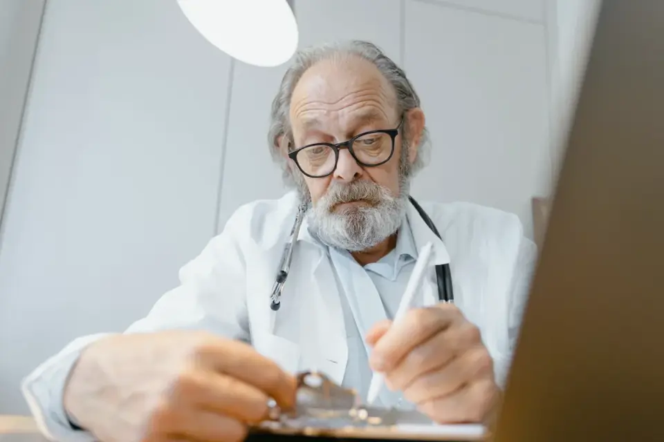 A veterinarian checking a senior dog&#x27;s hip and gait during an exam