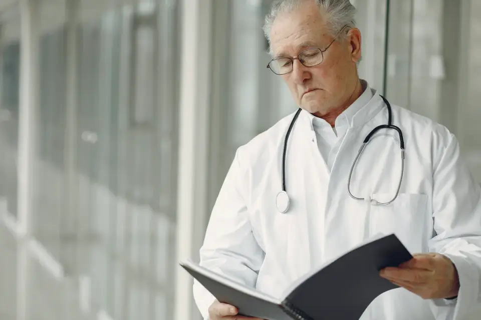 A veterinarian reviewing a supplement bag's ingredient panel next to a senior dog