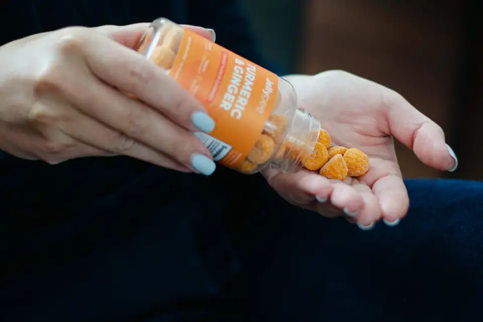 Hands comparing the ingredient panels of two dog supplement bottles